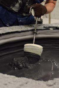 Slurry - Eagle Precision operator dipping a mold in a ceramic slurry